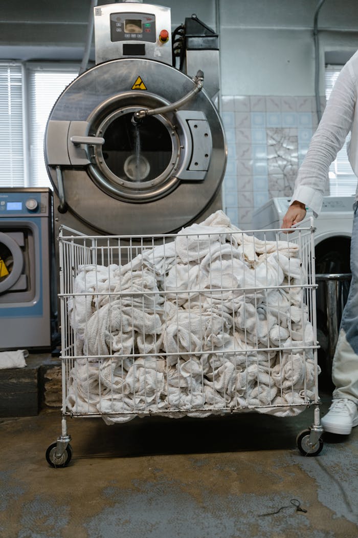 The Art of Drawing Readers In: Your attractive post title goes here A worker handling a cart of white linens in an industrial laundry setting.